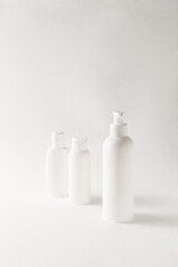 White bottles mockup for branding. Set of cosmetic products for cream, soup, deodorant, shampoo on light biege background. Tubes, dispensers and jars