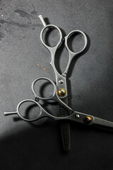 Metallic barber scissors on top of dark background.