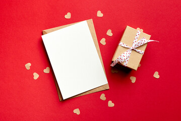 Valentines day card mockup with gift box and small hearts on red paper background
