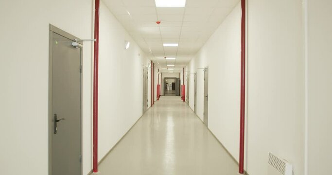 Long corridor with white walls, doors and red pipes on the walls, factory, 4k