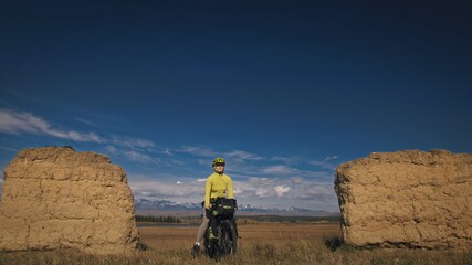 The woman travel on mixed terrain cycle touring with bikepacking. The traveler journey with bicycle...