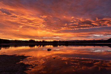 An intense, orange sunset, reflected in Lake Tekapo, Mackenzie District, Canterbury, New Zealand.