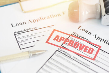 Loan application form with Rubber stamping that says Loan Approved, Financial loan money contract agreement company credit or person loan approval - 408913841