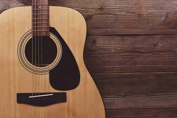Guitar resting on old wooden background, Close up acoustic guitar - top view Musical instrument for recreation or hobby passion concept - obrazy, fototapety, plakaty