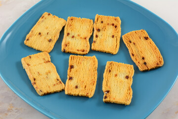 Cheddar cheese and raspberry crisps or biscuits on blue snack plate on table
