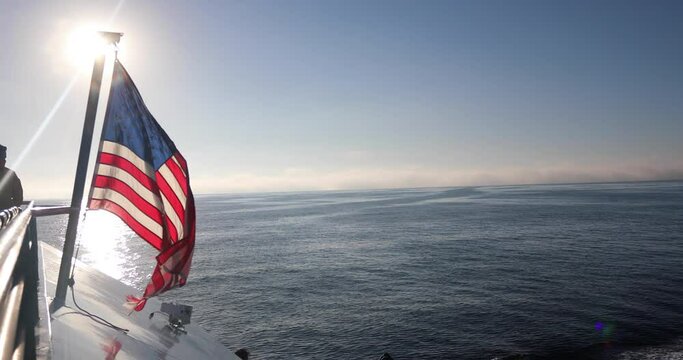 Boat With American Flag Sailing In Ocean