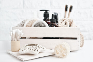 set of eco products for skin care in wooden box. brown cosmetic bottles for anti age care. Face rounds and natural exfoliating washcloth and reusable sponges. copy space. biodegradable bath tools.
