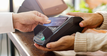 Customer using credit card for payment to owner at cafe restaurant, cashless technology and credit...