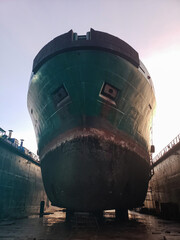 Industry view - Ocean Vessel in the dry dock in shipyard. Old rusty ship under repair. View from...