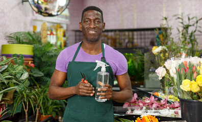 Portrait of African American male florist standing in his flower shop. Concept of small business..