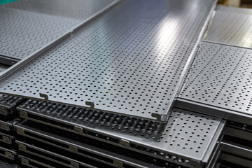 Metal shelves for storage racks. Products of the plant for the production of metal profiles, products stacked.