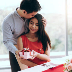 Man couple hand hold a romantic present red gift box give it to girlfriend.