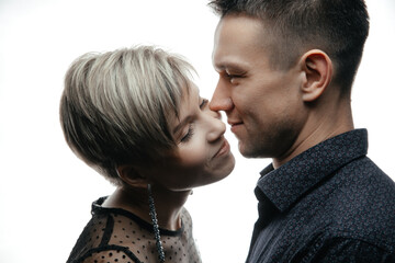 Portrait of a happy fashion couple hugging and kissing each other on an isolated white background.