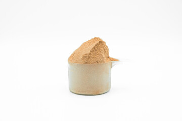 Whey protein powder on white background. Plastic measuring dietary spoon and heap of chocolate shake food drink. Sport workout gym nutrition energy replacement. Exercise muscle body fitness training.