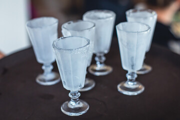 View of alcohol setting on catering banquet table, row line of ice cold vodka shots decorated catering bouquet table event