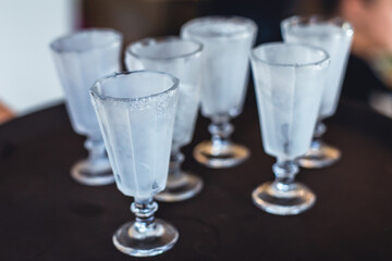 View of alcohol setting on catering banquet table, row line of ice cold vodka shots decorated catering bouquet table event
