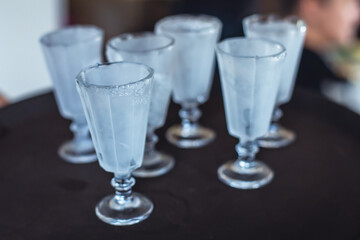 View of alcohol setting on catering banquet table, row line of ice cold vodka shots decorated catering bouquet table event