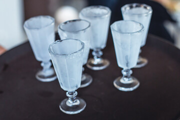 View of alcohol setting on catering banquet table, row line of ice cold vodka shots decorated catering bouquet table event