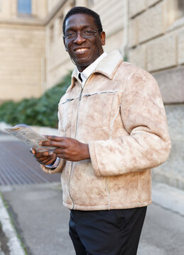 Positive Mature African Man Reading Guidebook Near Art Museum