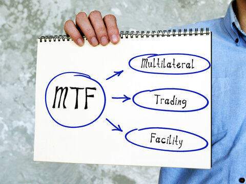 MTF Multilateral Trading Facility on Concept photo. Young Man Holding a notepad