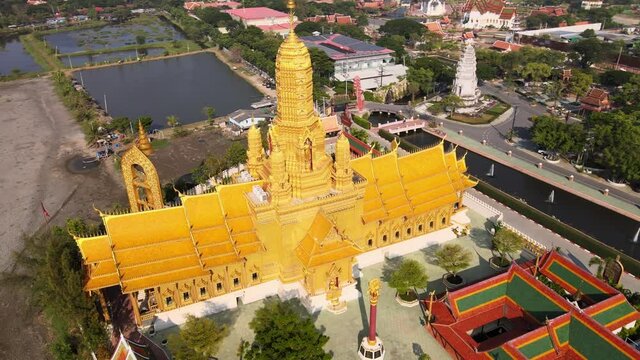 4k Aerial of Beautiful golden temple with the golden standing buddha statue in the Ancient City park, Muang Boran, Samut Prakan province.Thailand. Tourist attraction in Asia. Drone flies left to right