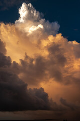 A huge fluffy colored clouds formation illuminated by a magic sunset light. Cumulonimbus.