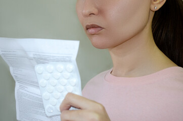 the girl reads the instructions for the pills