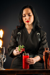 Young woman making bloody mary cocktail garnished with celery