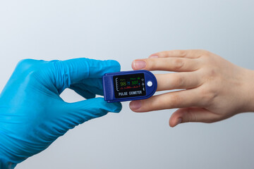 Doctor using pulse oximeter to check patient oxygen saturation