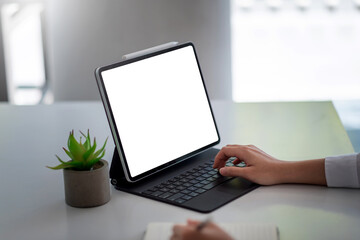 Business woman holding a pencil while taking notes with  tablet at the office. Blank white screen. Mock up.