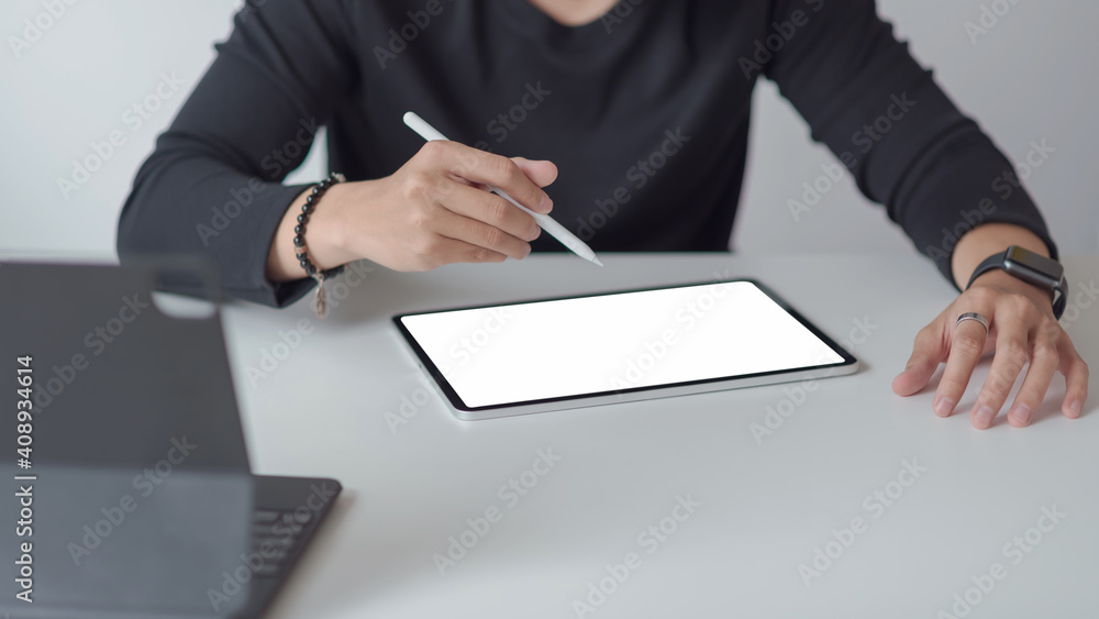 Poster man designer using a tablet to working at the office. blank white screen. mock up.