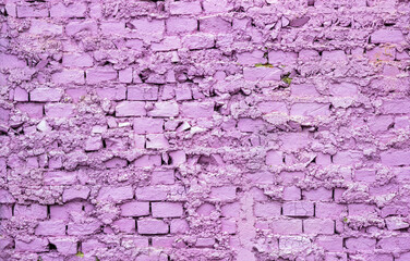 Background from an old and worn brick wall painted in purple