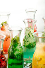 Fototapeta na wymiar Side view on assorted fresh fruit lemonades with herbs