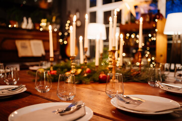 large square wooden table served for Christmas dinner. retro styled. Low light.