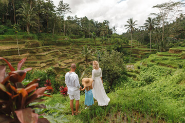 Family with littke kid travel around Bali island. Family holiday enjoying tropical island with paddy rice field in the background. Family summer vacation in Bali, Indonesia © Yevhenii