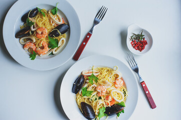 tasty gourmet spicy seafood pasta with shrimps, squid and mussels cooked with pink pepper and thyme