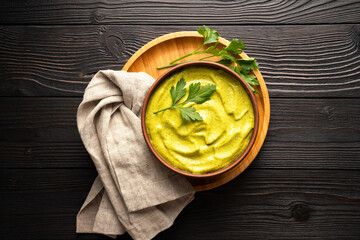 squash caviar with parsley in a bowl on a wooden background, flat lay