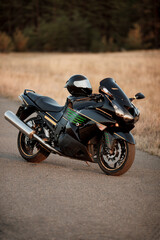 Sports motorcycle and safety helmet on it on the road with beautiful forest background © PRO STOCK