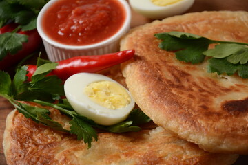 Traditional dishes of Israeli and Middle Eastern cuisine - Malawach with hard boiled eggs and tomatoes.  Malawach or malawah: traditional fried bread of Yemenite Jews