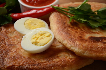 Traditional dishes of Israeli and Middle Eastern cuisine - Malawach with hard boiled eggs and tomatoes.  Malawach or malawah: traditional fried bread of Yemenite Jews