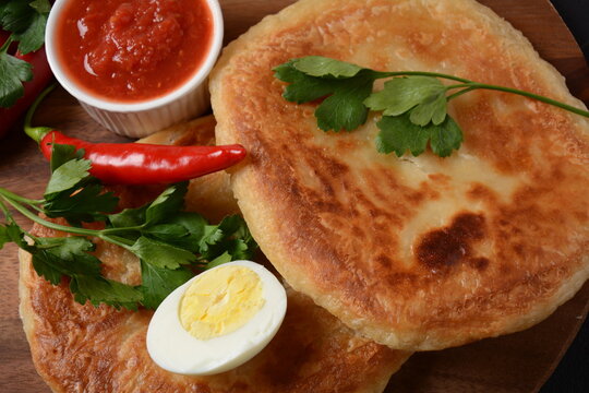 Traditional dishes of Israeli and Middle Eastern cuisine - Malawach with hard boiled eggs and tomatoes.  Malawach or malawah: traditional fried bread of Yemenite Jews