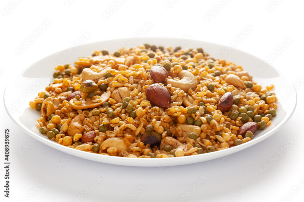 Wall mural 'Shahi Mixture' in a white ceramic plate, made with peanut, cashew, corn flakes, almonds, etc. Pile of Indian spicy snacks (Namkeen). Side view, against the white background