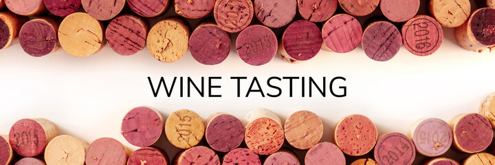 Wine tasting panoramic banner. Many wine corks, shot from the top on a white background