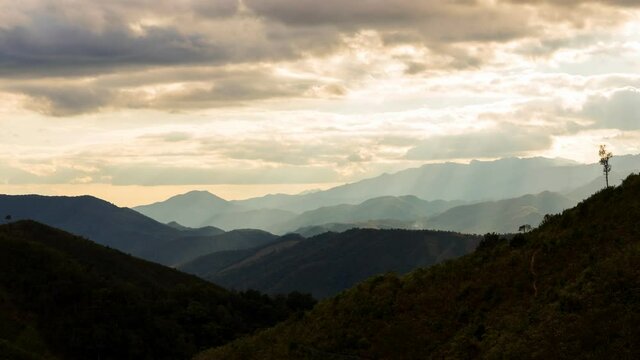 Time lapse view of sun rays emerging though clouds in mountain landscape in Huai Thon Village, Nan, Thailand. Footage timelapse nature landscape view and dramatic colored sky.