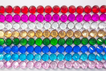 .Colorful diamonds are arranged neatly in a row on a white floor.