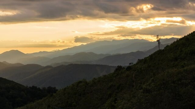 Time lapse view of sun rays emerging though clouds in mountain landscape in Huai Thon Village, Nan, Thailand. Footage timelapse nature landscape view and dramatic colored sky.