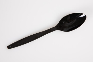 black spoon plastic recyclable biodegradable top view isolated on white background