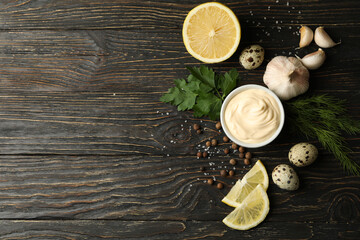 Bowl with mayonnaise and ingredients for cooking on wooden background