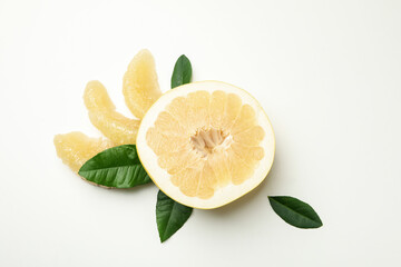 Half of pomelo fruit, slices and leaves on white background