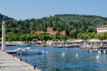 boats in the harbor of Garda and view of castle fo scaligeri 